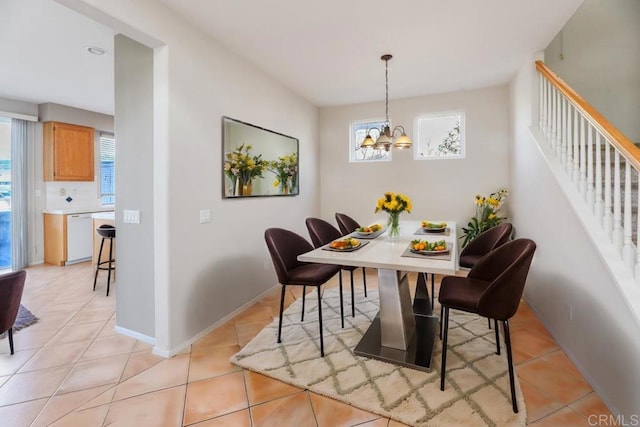 dining room with a wealth of natural light, stairs, and light tile patterned floors