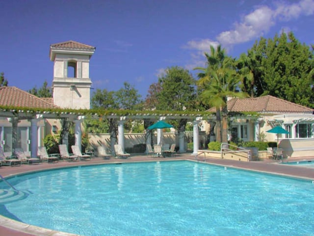 community pool with a pergola and a patio area