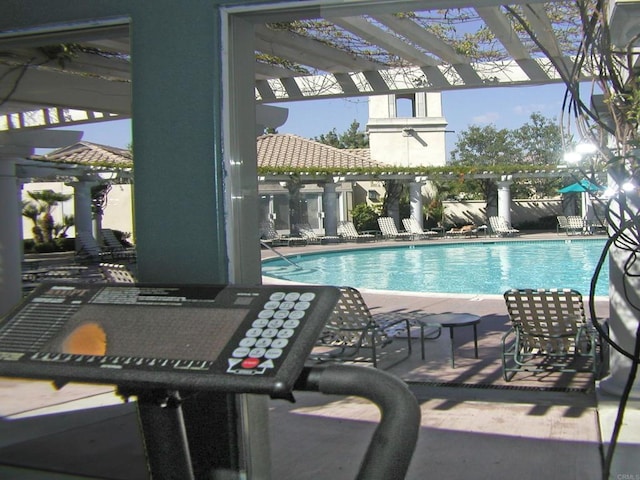 community pool with a pergola and a patio area