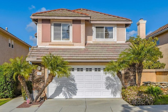 traditional-style home with a garage, stucco siding, a tile roof, and concrete driveway