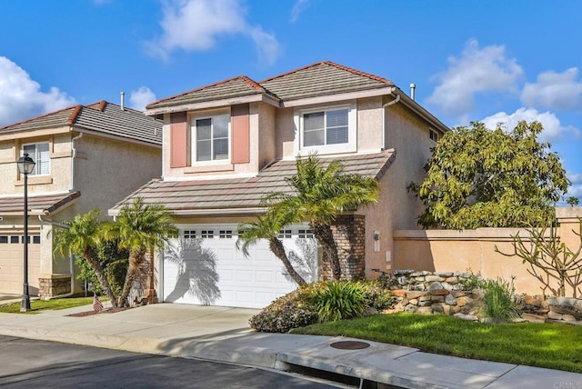 view of front of house with concrete driveway, a tile roof, stucco siding, and a garage