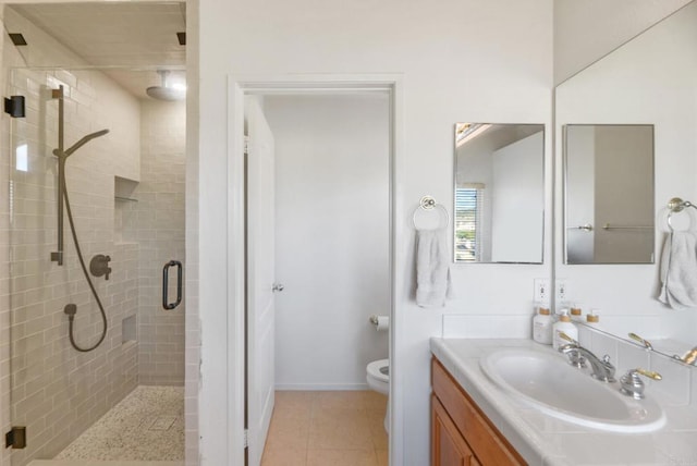 full bathroom featuring tile patterned floors, toilet, baseboards, a shower stall, and vanity