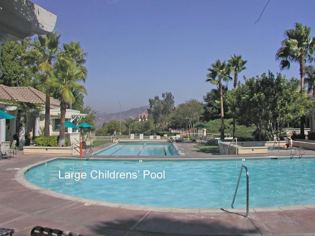 pool featuring a mountain view and a patio