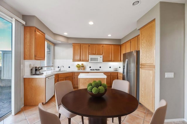 kitchen with light countertops, white appliances, recessed lighting, and a sink