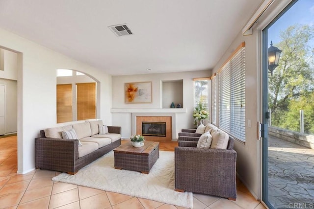 living area featuring a tile fireplace, visible vents, and light tile patterned floors