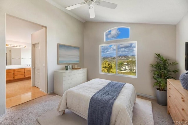 bedroom with ceiling fan, baseboards, light colored carpet, ensuite bath, and lofted ceiling