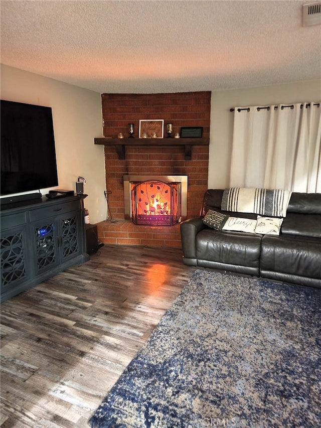 15433 Idaho Ln, Apple Valley, CA 92307 - living area with a textured ceiling, a fireplace, visible vents, and wood finished floors