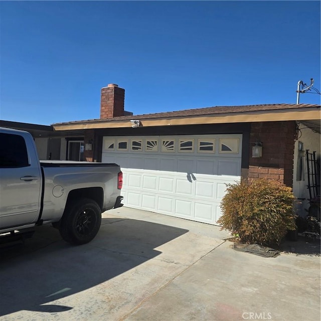 15433 Idaho Ln, Apple Valley, CA 92307 - view of side of home featuring driveway, an attached garage, and a chimney