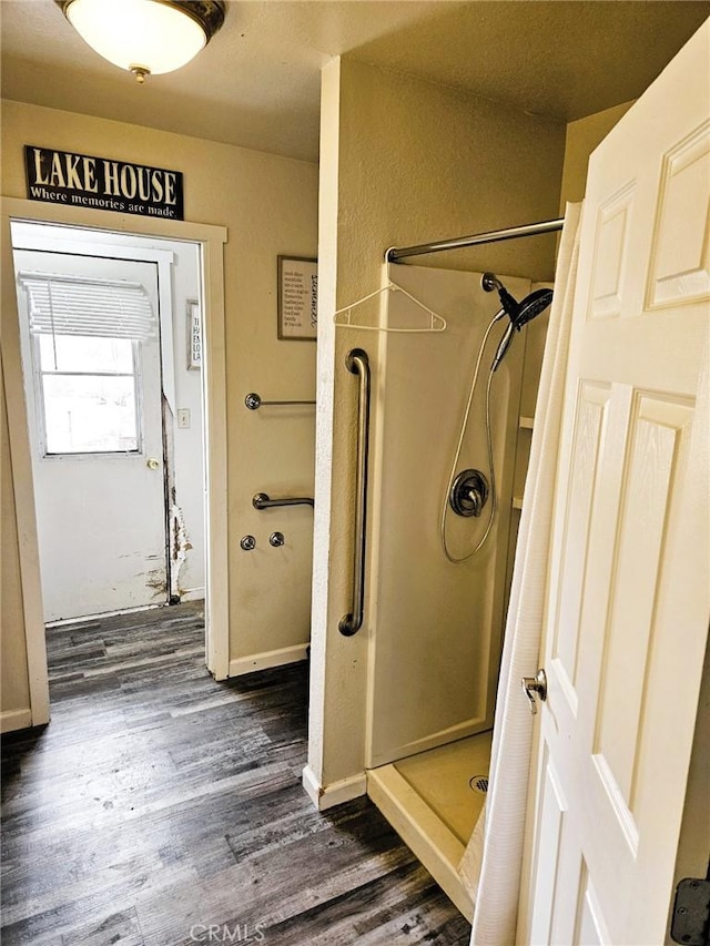 15433 Idaho Ln, Apple Valley, CA 92307 - bathroom featuring a stall shower, baseboards, and wood finished floors