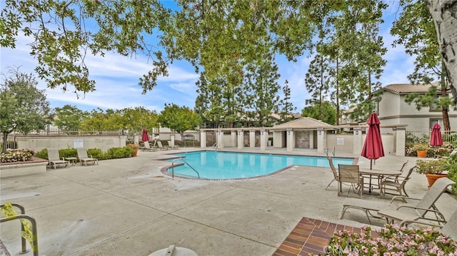 pool with a patio and fence