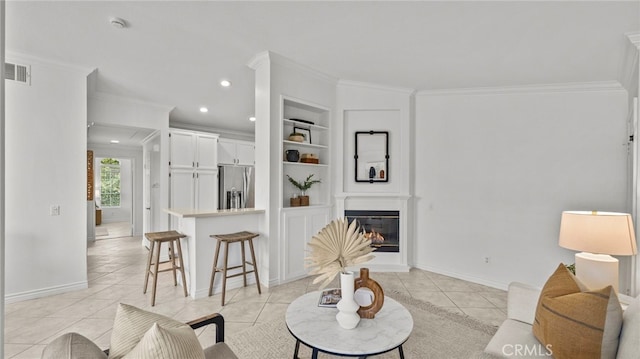 living room with built in features, light tile patterned floors, ornamental molding, and visible vents