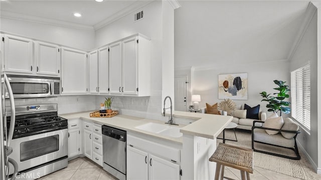 kitchen featuring visible vents, a sink, ornamental molding, stainless steel appliances, and light tile patterned flooring
