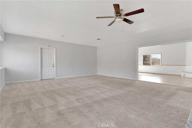 carpeted empty room featuring baseboards, ceiling fan, and visible vents