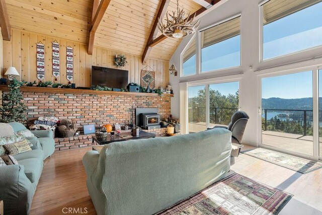 27721 Caribou Dr, Lake Arrowhead, CA 92352 - living area featuring wood finished floors, high vaulted ceiling, wooden ceiling with exposed beams, a wood stove, and wooden walls