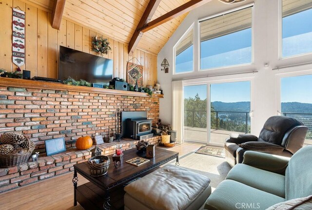 27721 Caribou Dr, Lake Arrowhead, CA 92352 - living area with wood finished floors, a wood stove, wooden ceiling with exposed beams, and high vaulted ceiling