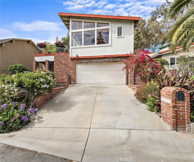 view of front of home with brick siding, driveway, and a garage