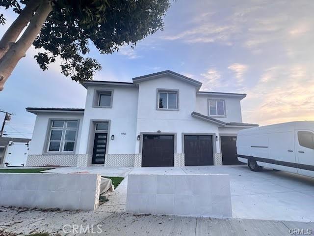 view of front facade with concrete driveway, stucco siding, and an attached garage