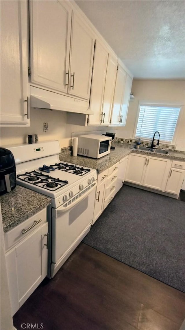 Palmdale, CA 93591 - kitchen with white appliances, under cabinet range hood, white cabinets, dark wood-type flooring, and a textured ceiling