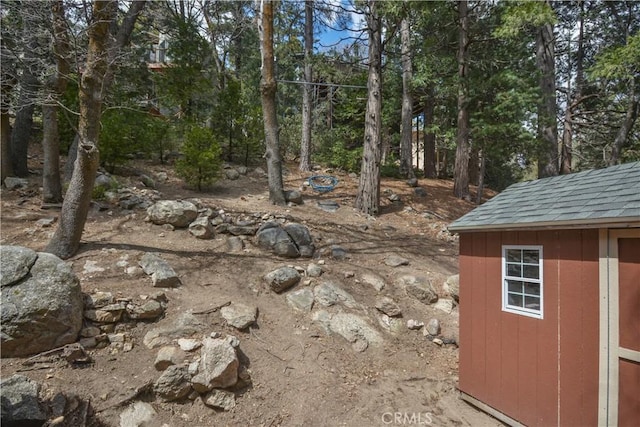 view of yard featuring an outdoor structure and a storage shed
