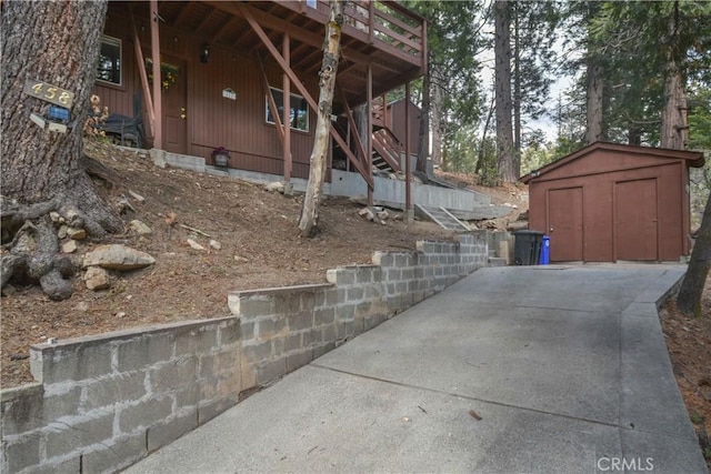 view of side of home featuring an outdoor structure, a storage unit, and stairway