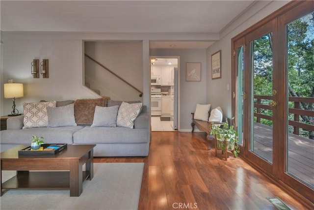 living area featuring stairs, visible vents, wood finished floors, and a ceiling fan