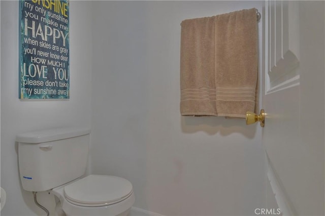 bathroom featuring baseboards and toilet