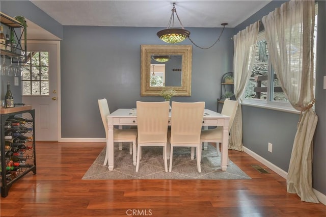 dining space featuring baseboards, visible vents, and wood finished floors