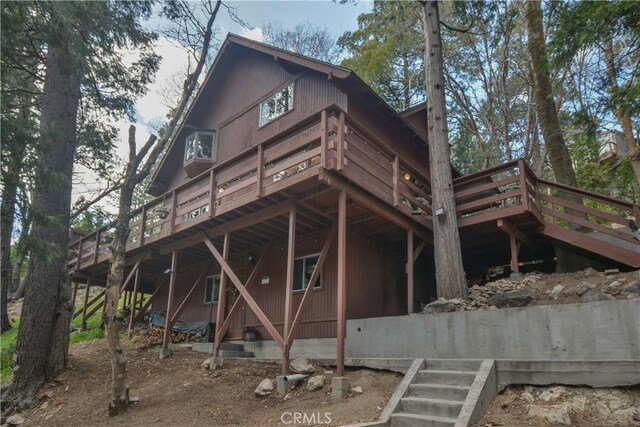 rear view of house with stairs and a deck