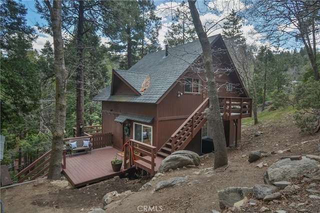 rear view of house with stairway and a deck