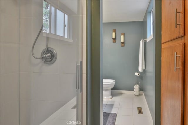 bathroom with toilet, baseboards, tile patterned flooring, and a shower stall
