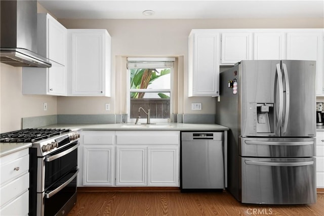 6050 Paseo Carreta, Carlsbad, CA 92009 - kitchen with wood finished floors, stainless steel appliances, white cabinets, a sink, and wall chimney exhaust hood
