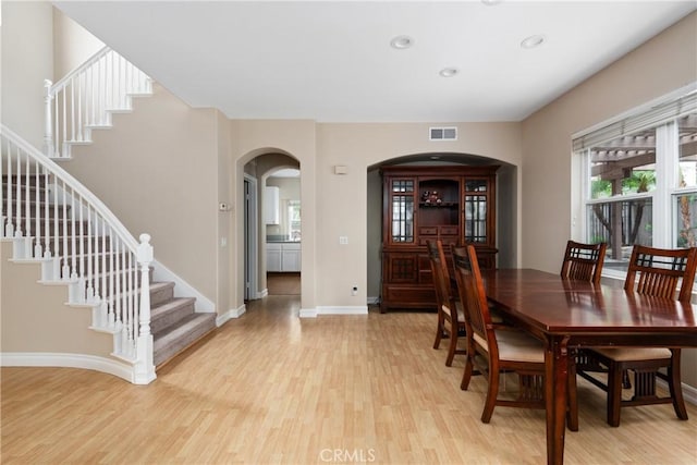 6050 Paseo Carreta, Carlsbad, CA 92009 - dining area with visible vents, light wood finished floors, arched walkways, and stairs