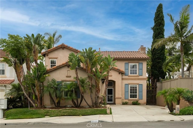 6050 Paseo Carreta, Carlsbad, CA 92009 - mediterranean / spanish house with fence, a chimney, stucco siding, and a tile roof