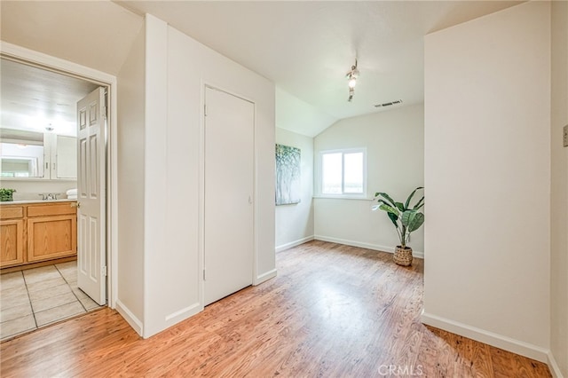 8029 Fruitland Ave, Winton, CA 95388 - spare room with light wood-style floors, visible vents, a sink, lofted ceiling, and baseboards