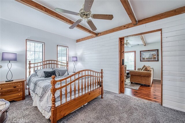 8029 Fruitland Ave, Winton, CA 95388 - carpeted bedroom featuring a ceiling fan, wooden walls, multiple windows, and beam ceiling