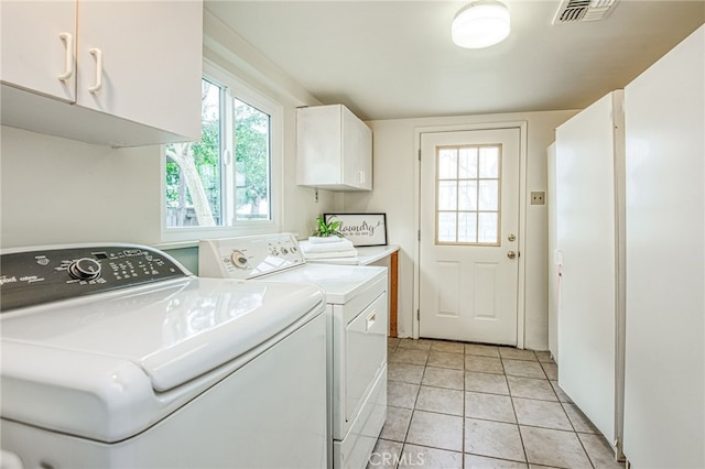 8029 Fruitland Ave, Winton, CA 95388 - laundry area with washing machine and dryer, light tile patterned floors, visible vents, and cabinet space