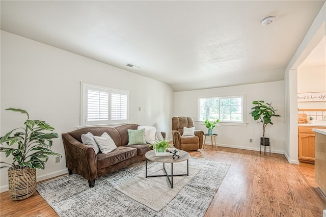 8029 Fruitland Ave, Winton, CA 95388 - living area featuring visible vents, baseboards, light wood finished floors, and vaulted ceiling