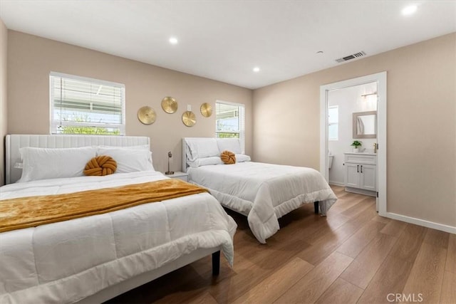 bedroom with connected bathroom, baseboards, visible vents, light wood-style floors, and recessed lighting