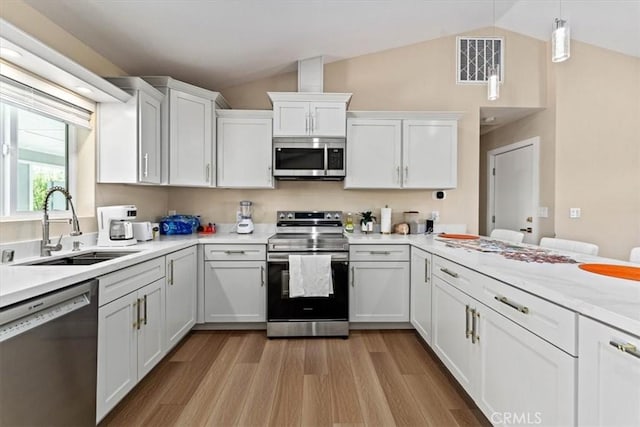 kitchen featuring light countertops, visible vents, white cabinets, appliances with stainless steel finishes, and a sink