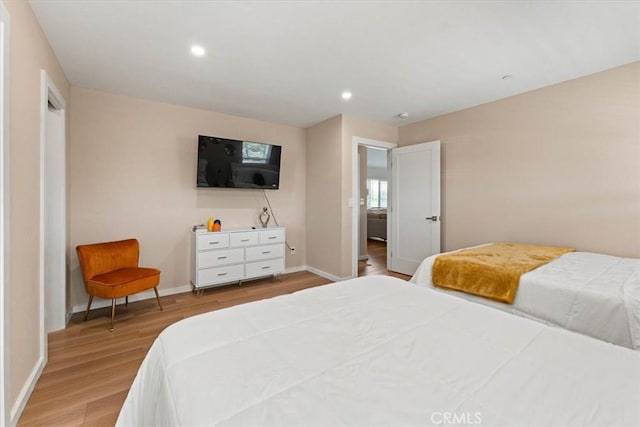 bedroom with baseboards, recessed lighting, and light wood-type flooring