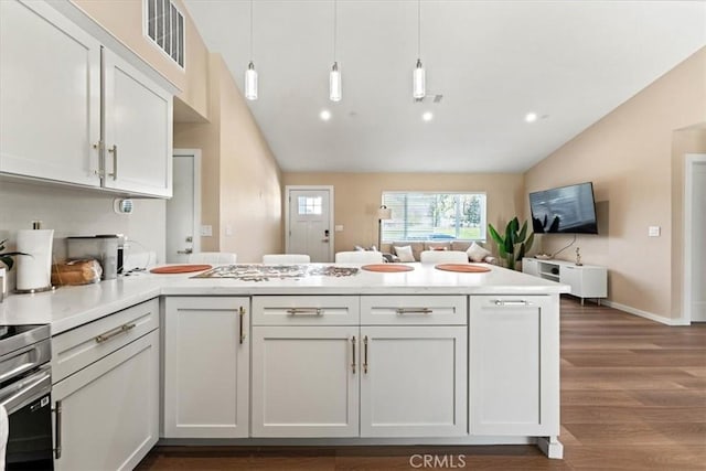 kitchen featuring open floor plan, lofted ceiling, dark wood-type flooring, visible vents, and a peninsula