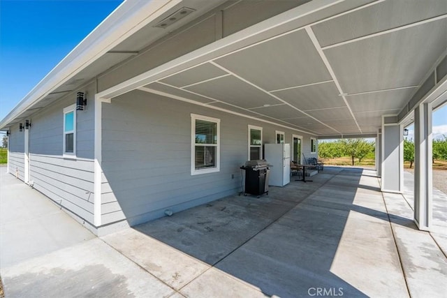 view of patio / terrace with an attached carport and a grill