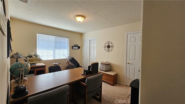office featuring light colored carpet and a textured ceiling