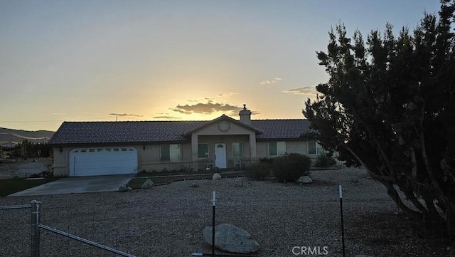 single story home featuring a garage, a chimney, concrete driveway, fence, and stucco siding