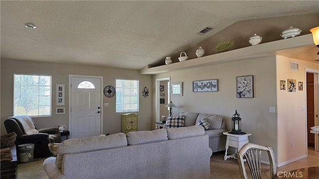 living room featuring visible vents, a textured ceiling, and vaulted ceiling