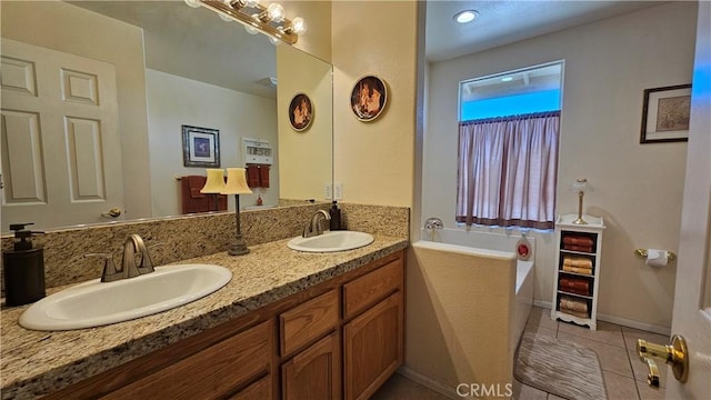 full bathroom featuring tile patterned floors, a garden tub, double vanity, and a sink