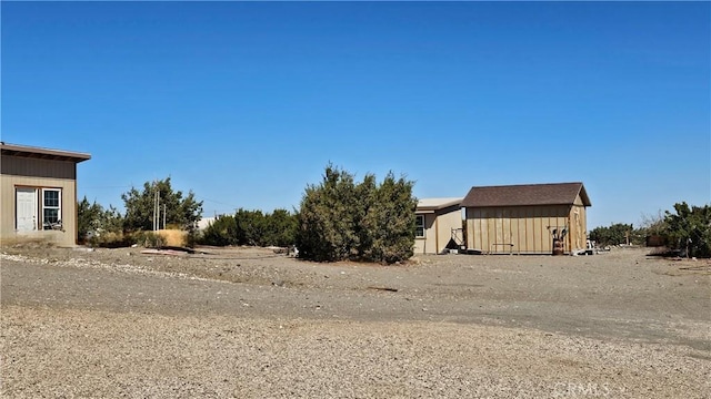 view of yard featuring a storage shed and an outbuilding