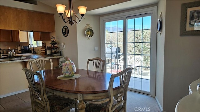 dining room with tile patterned flooring, baseboards, and a chandelier