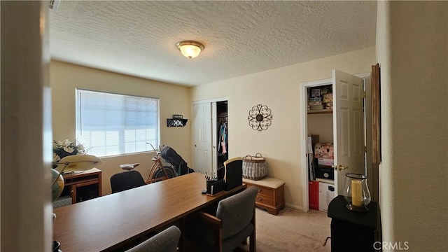home office featuring light carpet and a textured ceiling