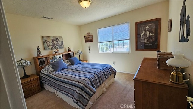 carpeted bedroom with a textured ceiling, baseboards, and visible vents